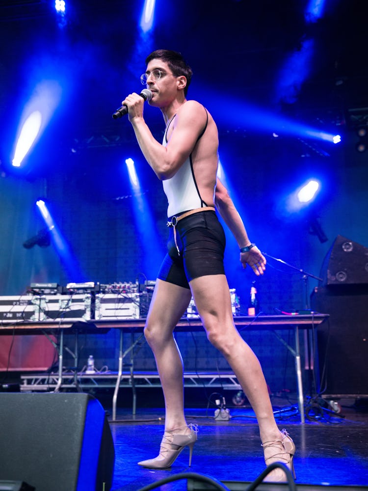 A performer with a microphone wearing a white top, black short and beige heels at the Pitchfork Musi...