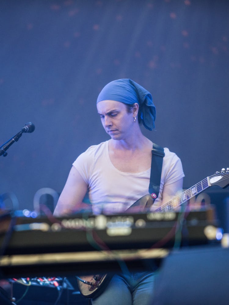 A man in a white shirt and a blue scarf on his head playing on a guitar at the Pitchfork Music Festi...