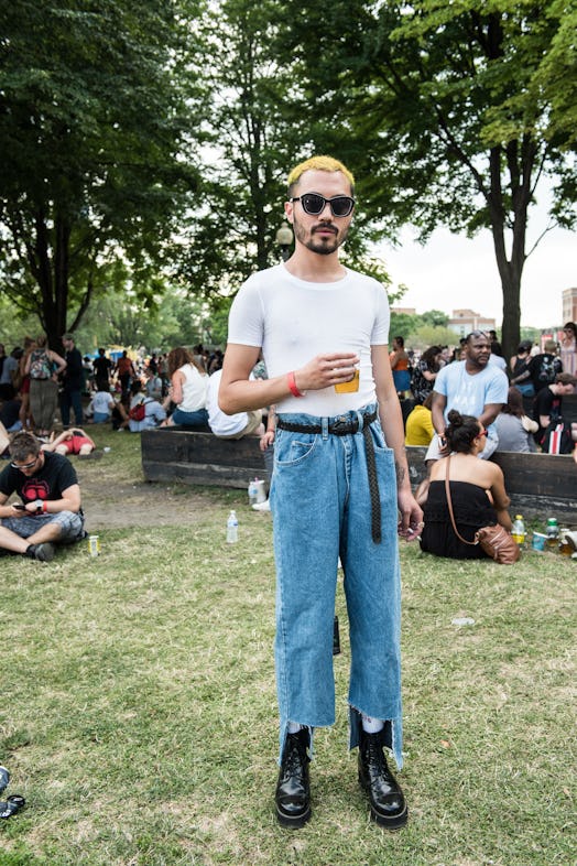A Pitchfork Music Festival attendee in a white T-shirt and blue denim jeans and black sunglasses
