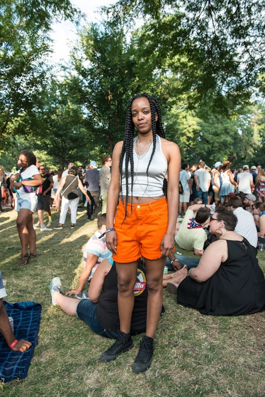 A woman in a white top and orange shorts attending the Pitchfork Music Festival