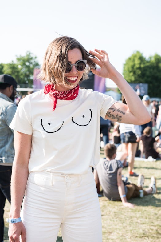 A smiling woman in a white shirt with black print, white trousers and a red bandana attending the Pi...