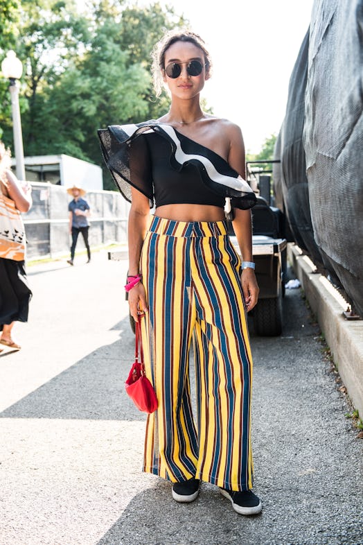 A woman in a black asymmetric top and yellow-black striped pants attending the Pitchfork Music Festi...