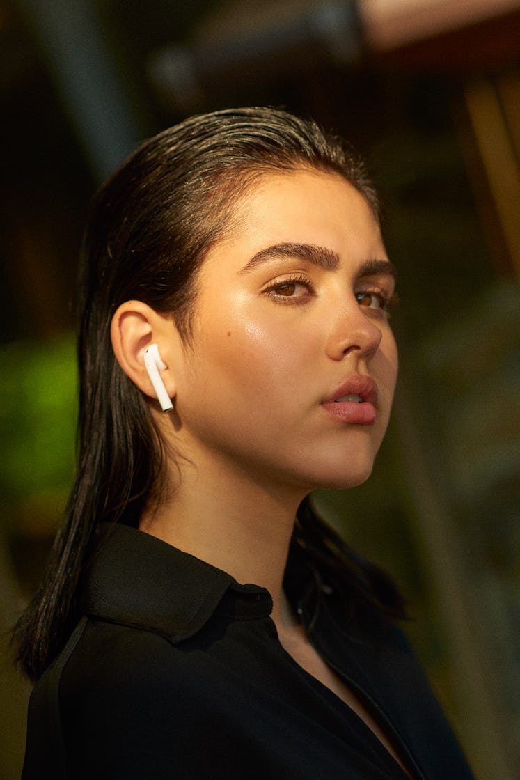 Amelia Gray Hamlin in a black shirt and white earbuds