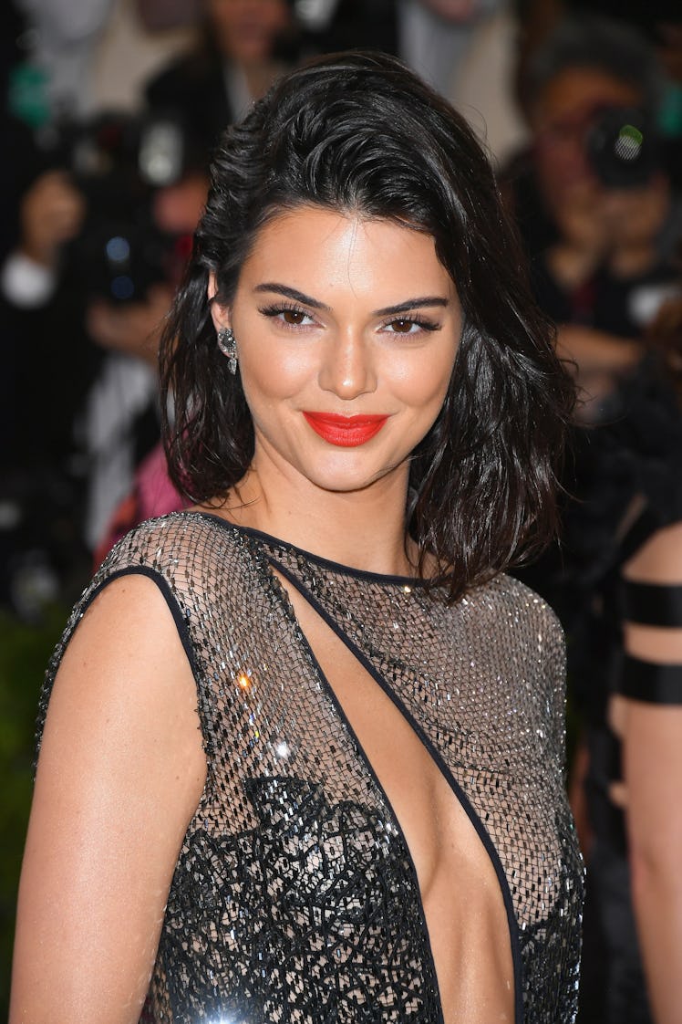 Kendall Jenner rocks a stunning coral lip that perfectly complements her sleek, wet waves.