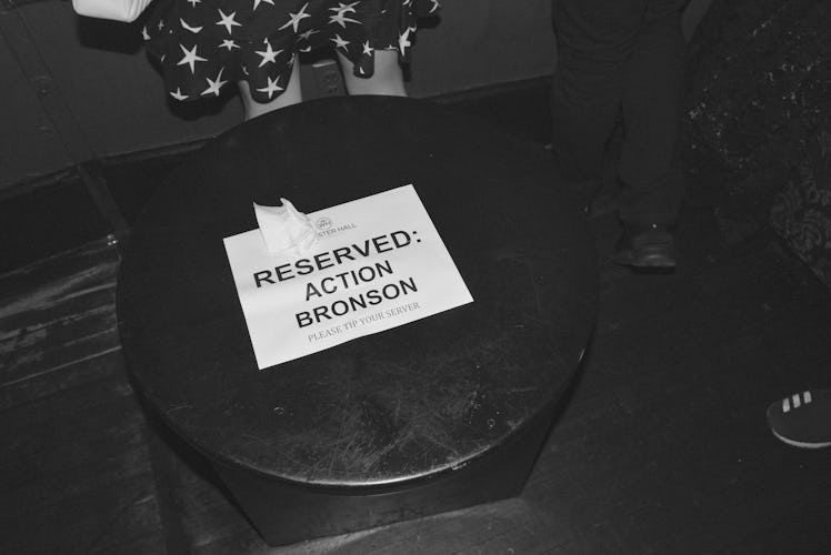 A reserved table with a paper with "Reserved: Action Bronson" text