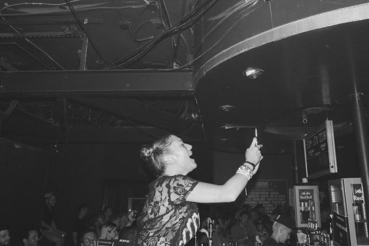 A woman recording the concert of Action Bronson with her mobile phone
