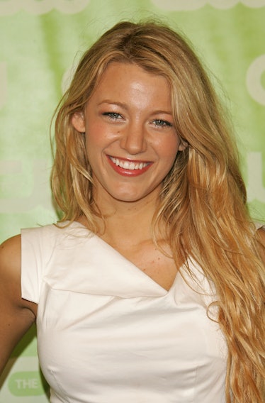 Blake Lively wearing her long natural wavy haircut styled with a white dress at the CW Network Upfro...