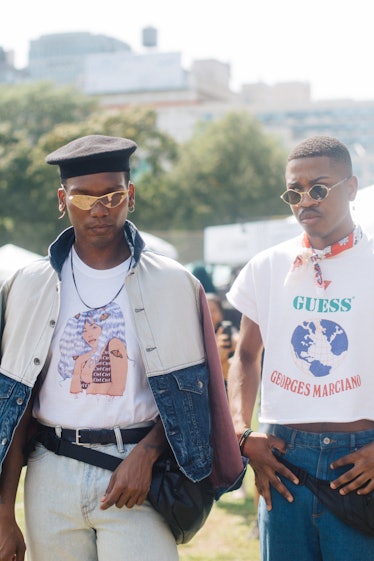 Two men at the Afropunk Festival, one is wearing a denim jacket and black beret and the other a whit...