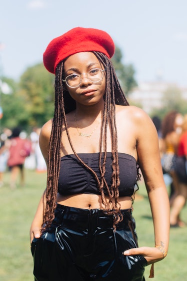 A woman with dreadlocks, a black bandeau top, black leather pants and a red beret at Afropunk Festiv...