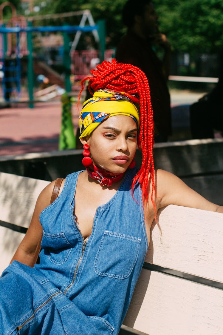 A woman with red dreadlocks and a denim jumpsuit at the Afropunk Festival 