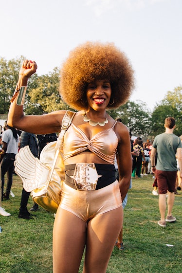 A woman with a light brown afro and a golden bralette with matching short at the Afropunk festival 