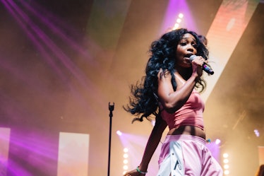 SZA performing at Afropunk Festival in a pink top and pink pants 