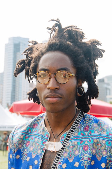 A man with multiple dreadlock ponytails and a blue jacket at Afropunk Festival 
