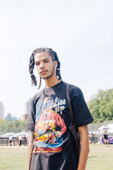 A man with two dreadlock ponytails, one at the front and one at the back during Afropunk Festival 