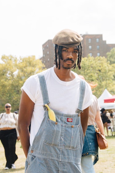 A man with dreadlocks, a beret, a white t-shirt and denim overalls at Afropunk Festival 