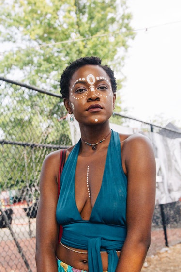 A woman with short hair, white face paint and a blue top at Afropunk Festival