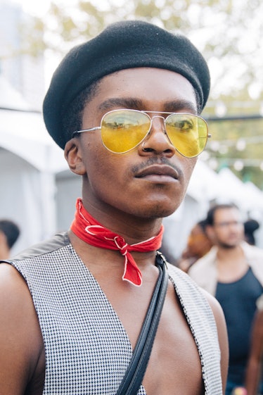 A man wearing a black beret, yellow sunglasses and a grey vest at Afropunk Festival