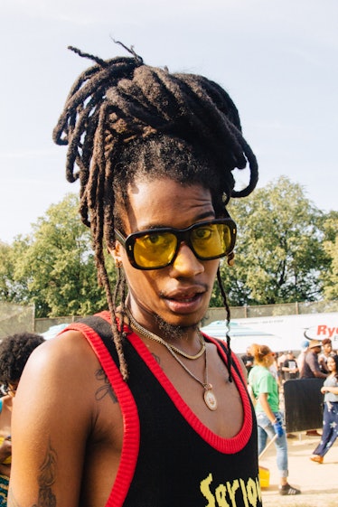 A man with a dreadlock ponytail and yellow sunglasses at Afropunk Festival 