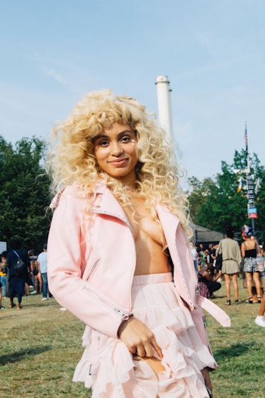 A blonde curly woman in a pink jacket and matching skirt at Afropunk Festival