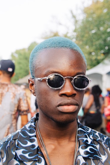 A man with light blue hair and circular sunglasses at Afropunk Festival