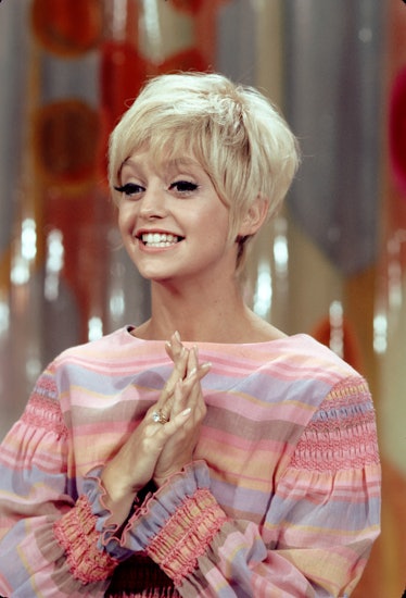 Goldie Hawn in a colorful patterned dress, smiling and wearing a tousled Pixie cut
