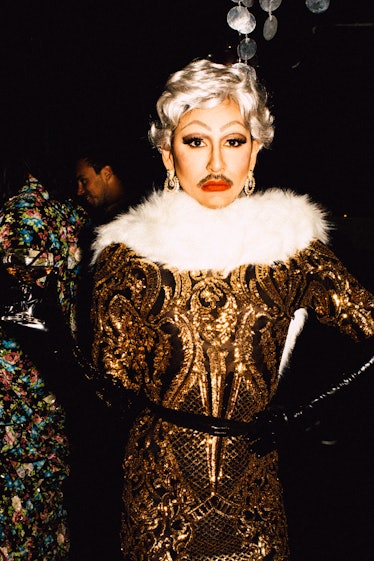 An attendee in a gold-black dress with white fur collar at Marc Jacobs and RuPaul’s Drag Ball at New...