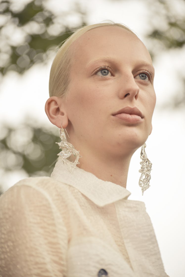 A closeup of a blonde model with a low ponytail and statement earrings at the Maryam Nassir Zadeh sh...