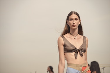 A model walking the runway at the Maryam Nassir Zadeh show wearing a bralette and high-waisted pants...
