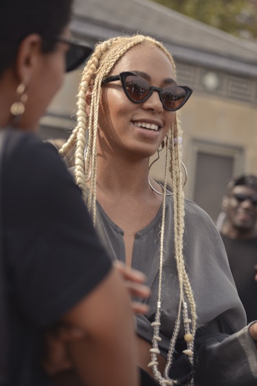 Solange with blonde hair and sunglasses smiling at the Solange with blonde hair and sunglasses angle...