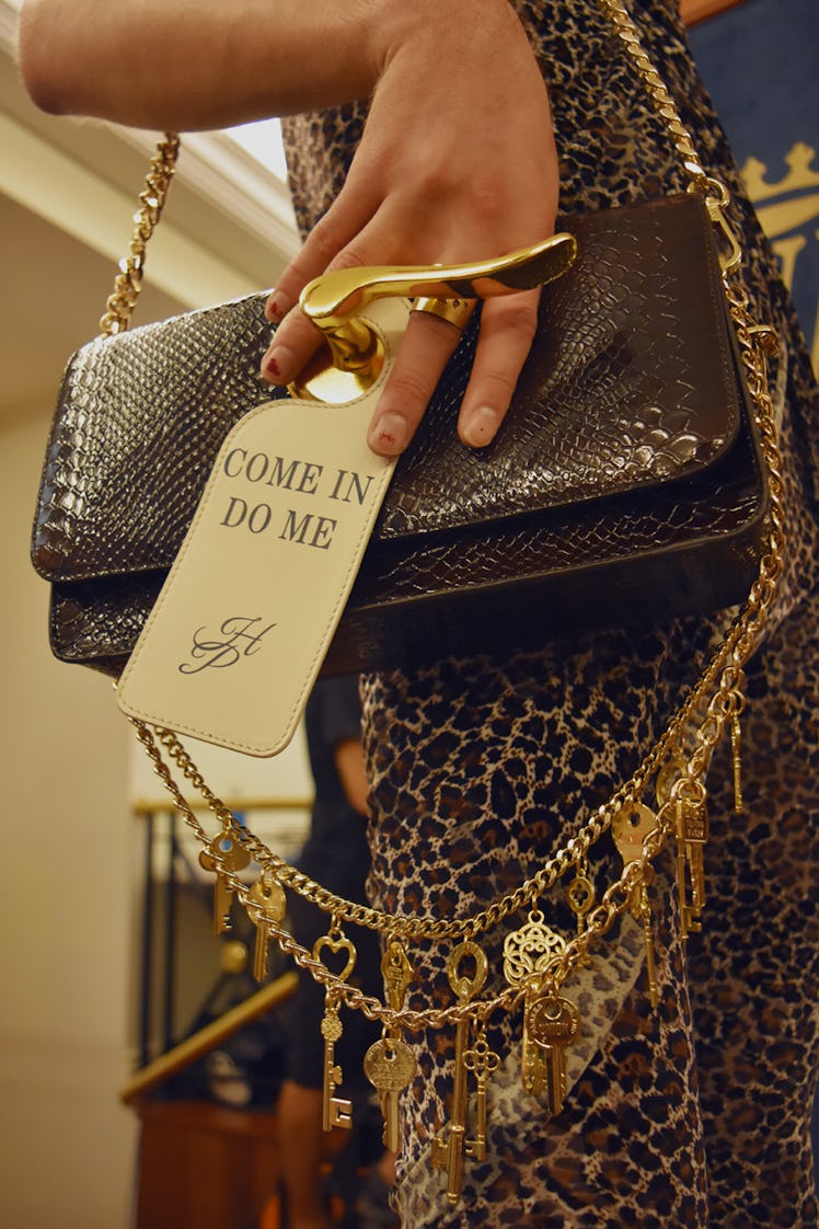 A close-up of a model holding a brown leather bag with a door knob at the Palomo Spain SS18 runway