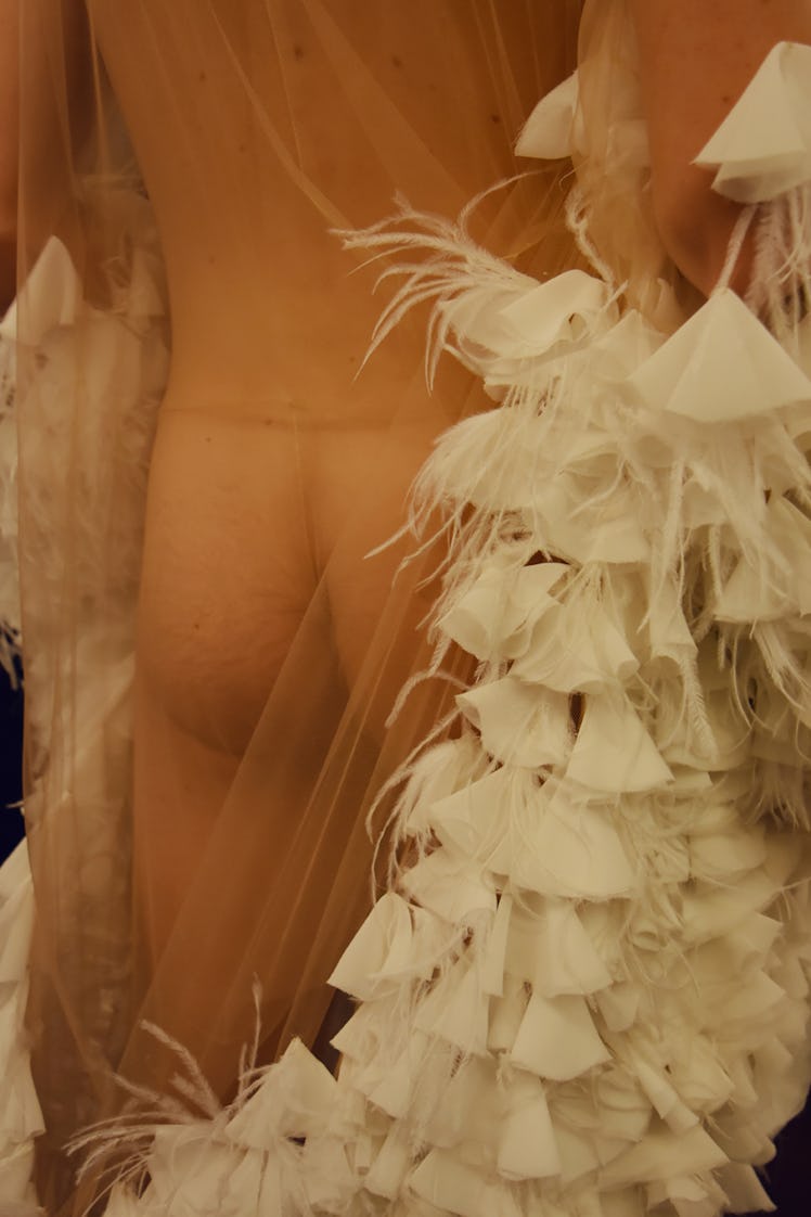 Back of a model covered in sheer fabric and white feathers, ruffles, and tulle at Palomo Spain SS18
