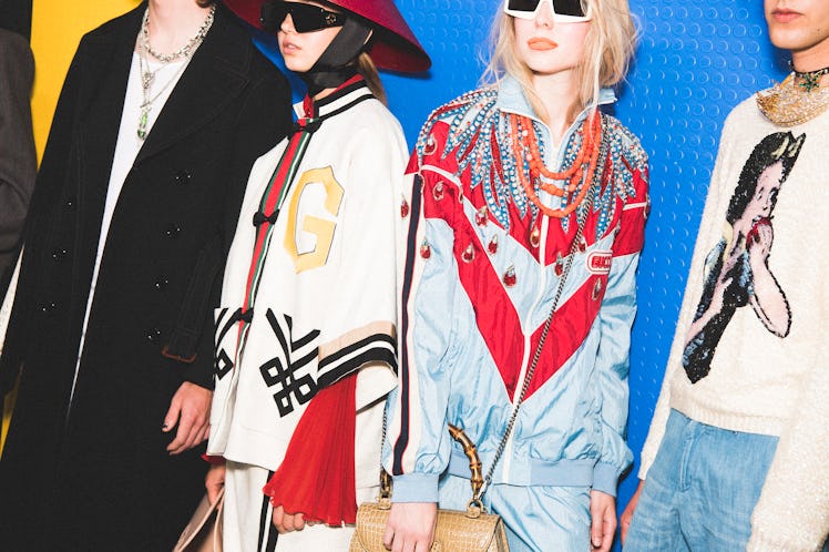 Models standing backstage at the Gucci SS18 show looking into the distance 