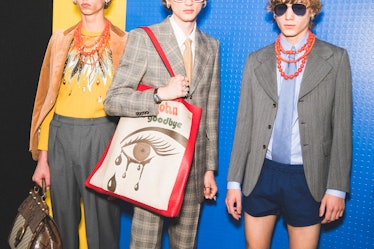Models posing backstage at the Gucci SS18 show with a large tote bag and wearing blazers 