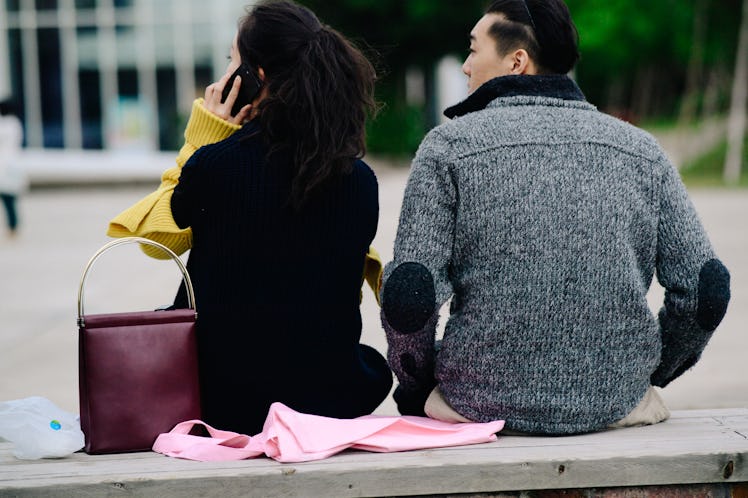 A man and a woman sitting next to each other on a park bench