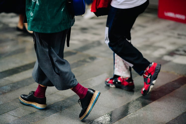 Legs of two women walking while wearing baggy pants