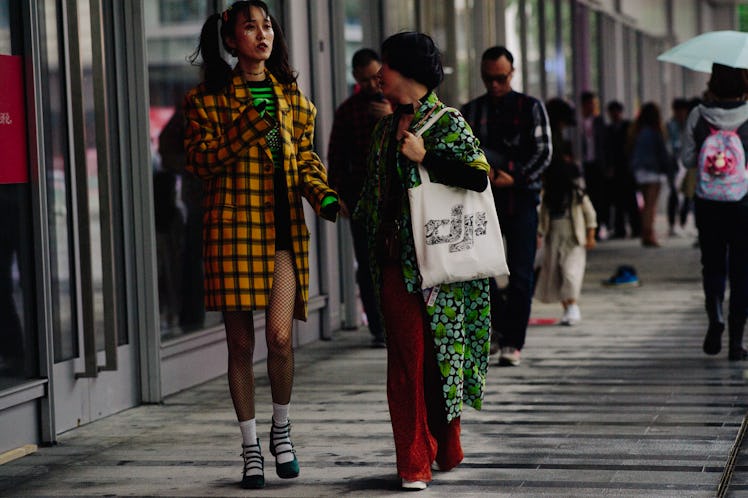 A woman walking while wearing a yellow and black coat