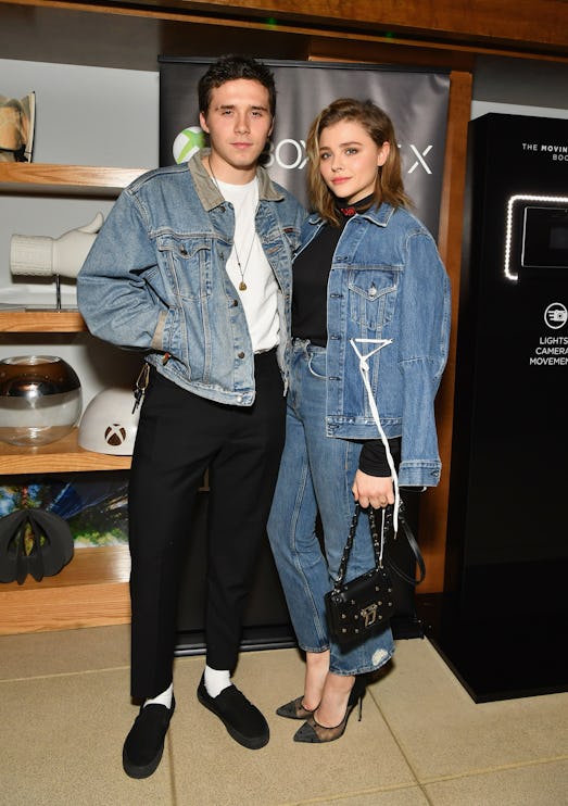 Chloë Grace Moretz in a blue denim suit and Brooklyn Beckham in a denim jacket, white top and black ...