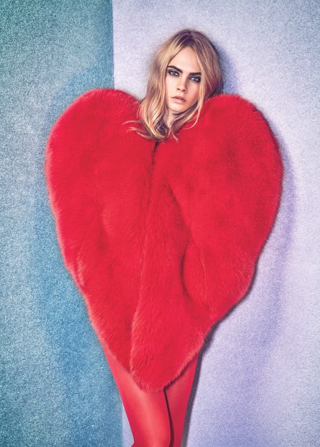 Cara Delevingne posing in a red heart-shaped faux fur overall