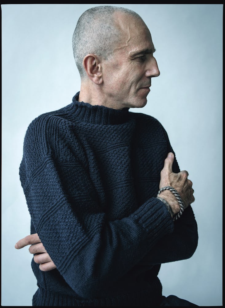 Daniel Day-Lewis in a black knit sweater with his arms crossed