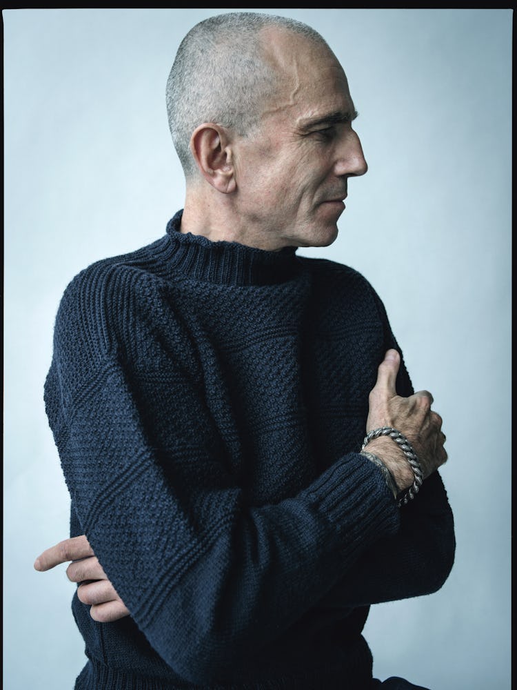 Daniel Day-Lewis in a black knit sweater with his arms crossed