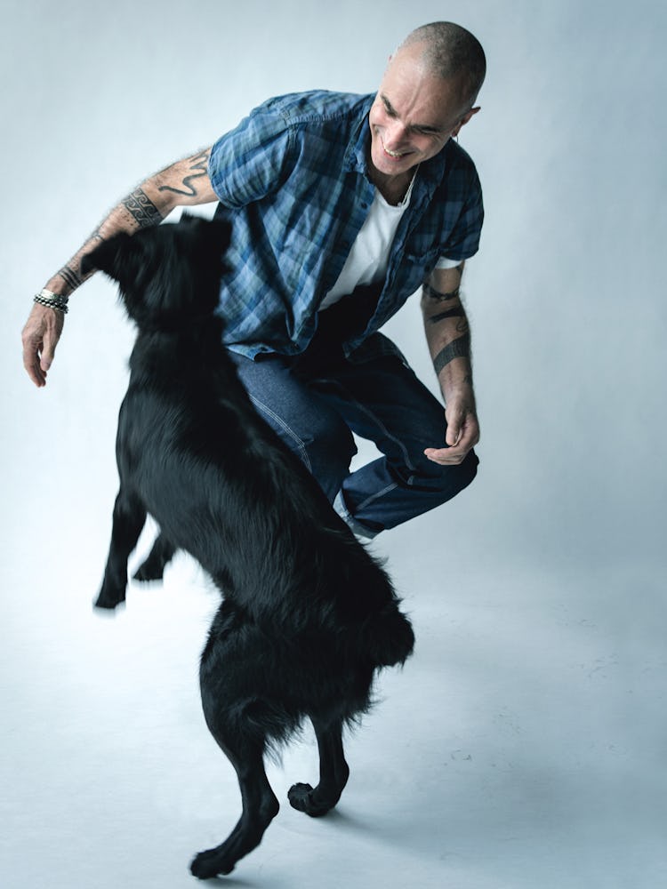 Daniel Day-Lewis in a white shirt, blue checked shirt and blue denim jeans smiling next to a black d...