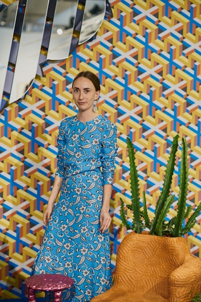 A woman posing in a blue print dress