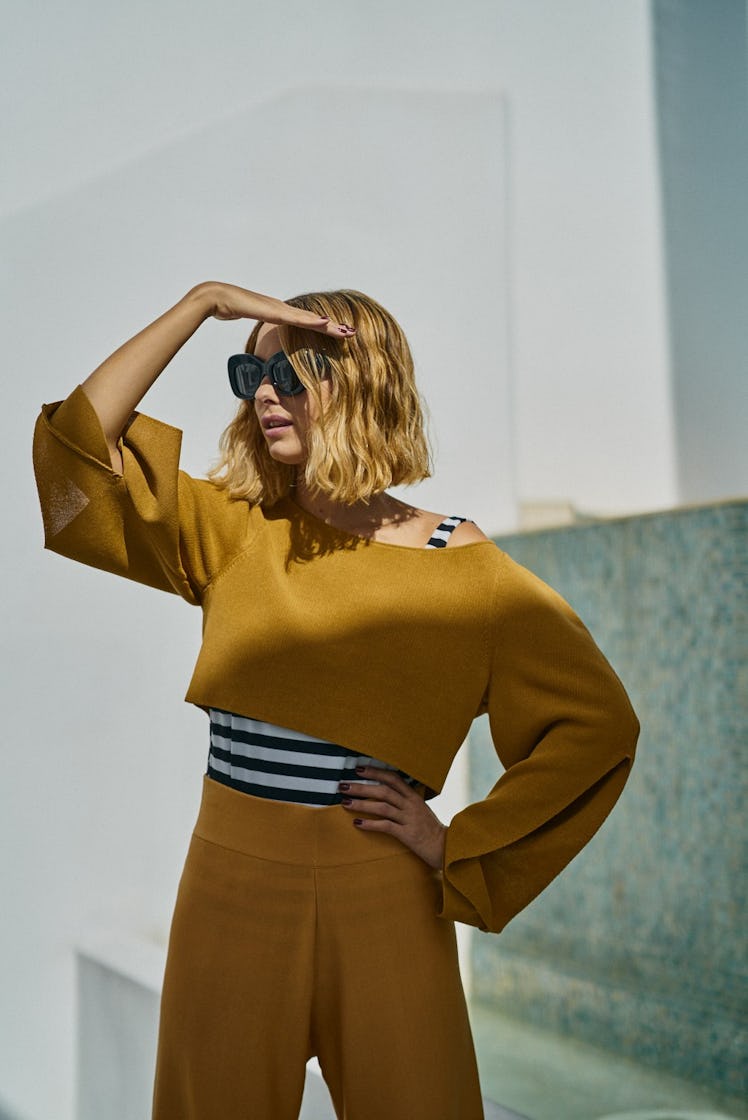 A woman wearing an orange co-ord set posing for a photo at Art Basel Miami international art fair