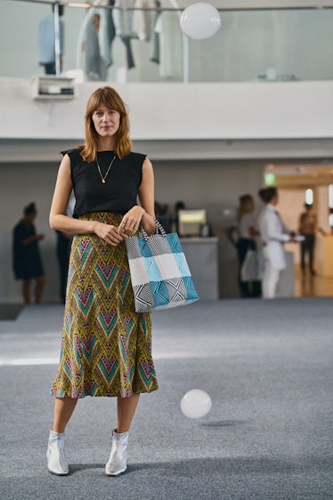 A woman wearing a printed skirt and a black t-shirt at Art Basel Miami international art fair