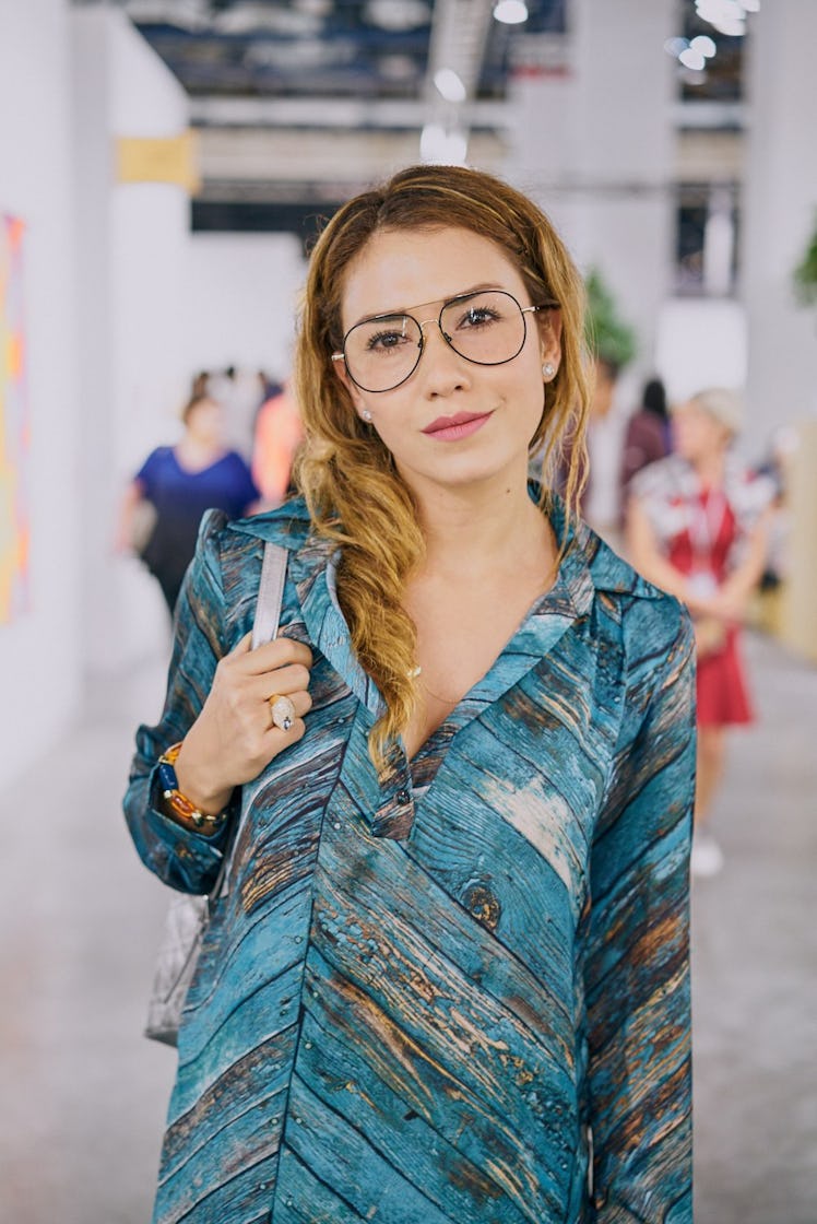A woman wearing a blue printed shirt at Art Basel Miami international art fair