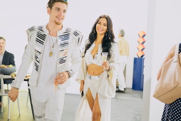 A man and a woman wearing matching white outfits at Art Basel Miami international art fair