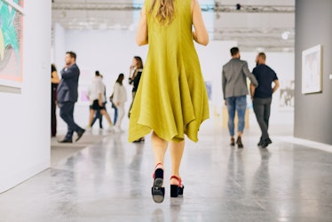 A woman wearing a bright yellow dress at Art Basel Miami international art fair
