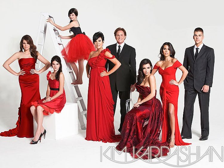 A Christmas card with the Kardashians and Jenners in all red with Bruce in a black tux and white shi...