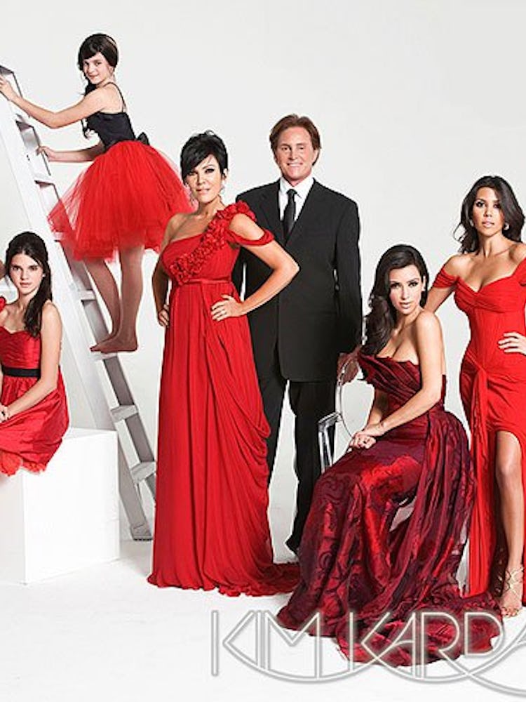 A Christmas card with the Kardashians and Jenners in all red with Bruce in a black tux and white shi...