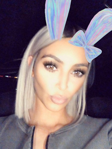 Kim Kardashian pouting with a bunny-ear snapchat filter on and her hair in a short platinum blonde b...